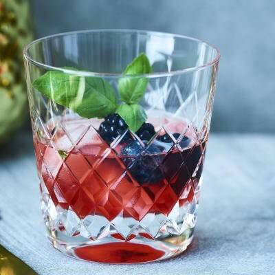 Cocktail van whisky, blauwe bessen en basilicum